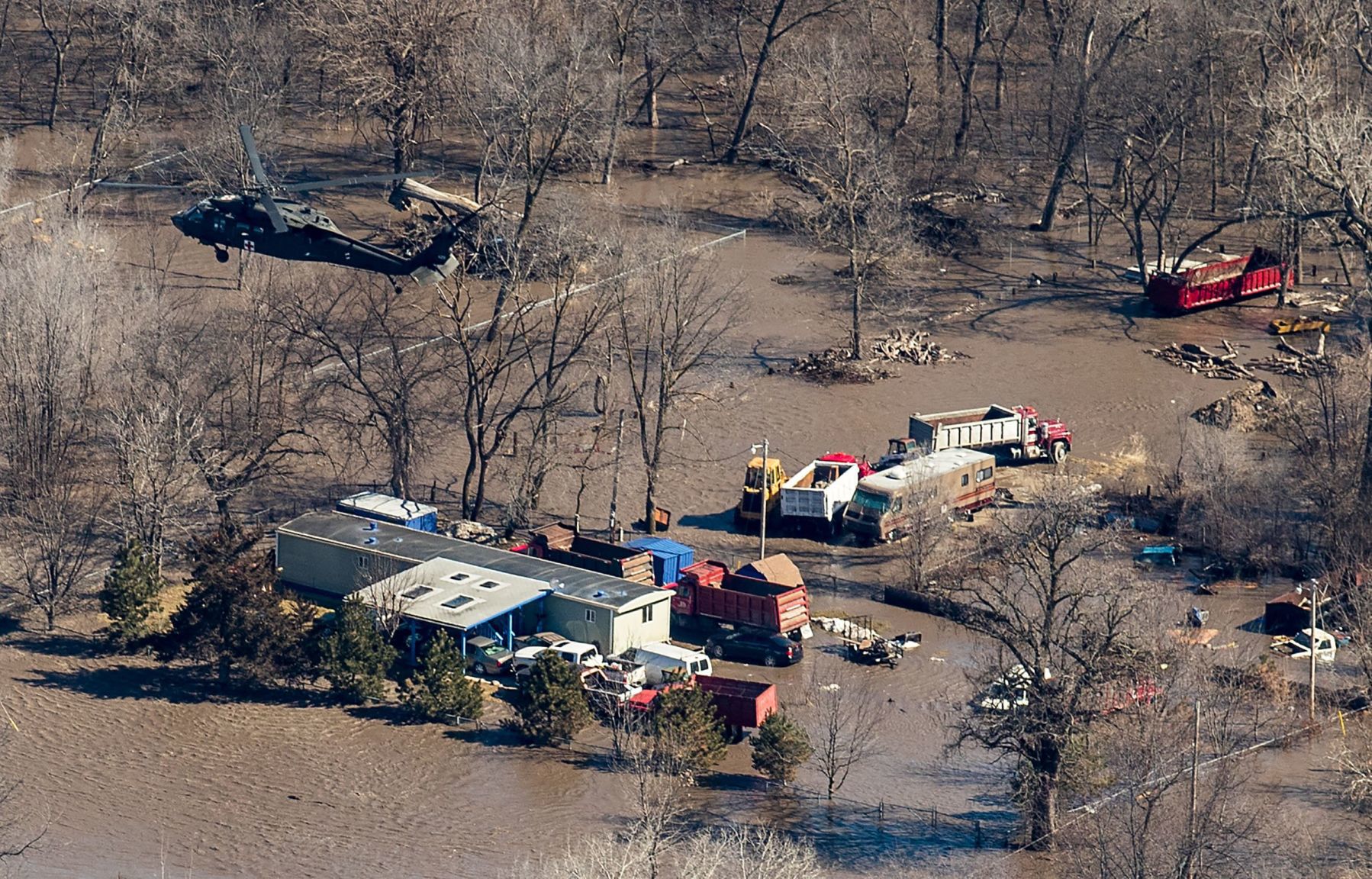 A Nebraska National Guard helicopter flies over flooded Waterloo on Friday.